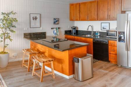 a kitchen with a counter and chairs and a refrigerator at Condo on Beach with AC in Laie