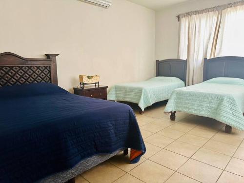 - une chambre avec 2 lits et une fenêtre dans l'établissement Casa Coy, à Ciudad Valles
