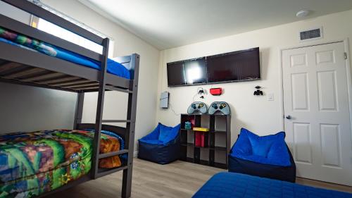 Long Beach Cozy Remodled Home في لونغ بيتش: غرفة نوم مع سرير بطابقين وتلفزيون وباب