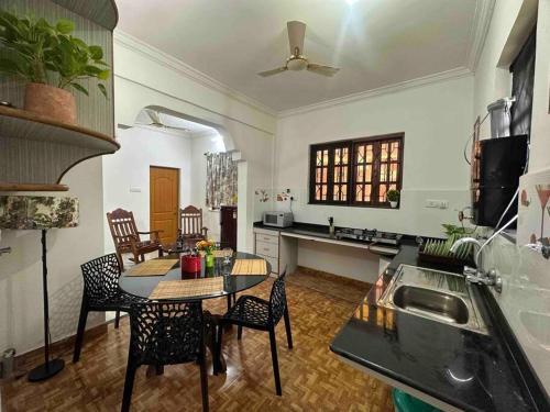 a kitchen and dining room with a table and chairs at Cool viva Goa villa near beach in Colva