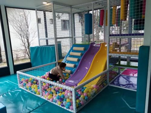 a young child playing in a playground with a slide at Mans lux 8 Apartman in Zlatibor