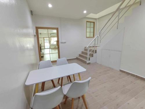 une salle à manger avec une table et des chaises blanches dans l'établissement Rest24 Betong, à Betong