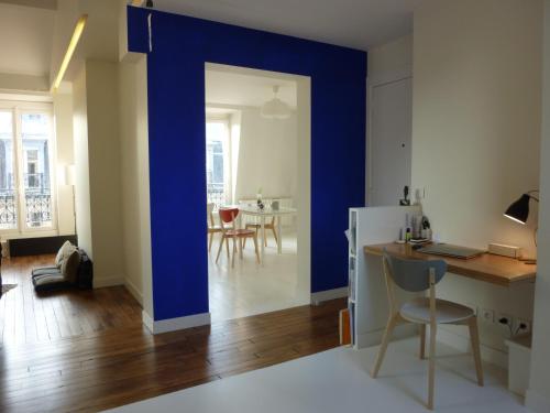 un salon avec un mur bleu et une cuisine dans l'établissement 3 rooms apartment business rooftop view to Montmartre, à Paris
