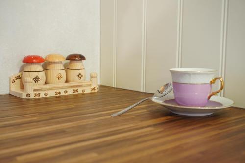 a cup and a saucer on a wooden table with a bowl and a cup at Jariabka Chalet Zrub Nízke Tatry in Jarabá