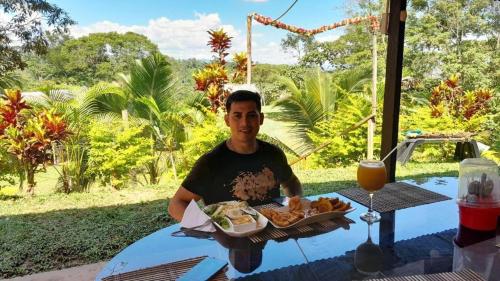 a man sitting at a table with a tray of food at CHOCLINO ECOLODGE -Bungalows con Piscina privada, Mirador y Tours en la selva in Tarapoto