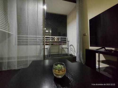 Apartamento La Florida Mirador في سانتياغو: وعاء من الفواكه على طاولة مع تلفزيون