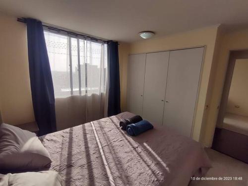 Un dormitorio con una cama con una bolsa. en Apartamento La Florida Mirador, en Santiago