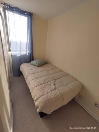 ein kleines Bett in einem Zimmer mit Fenster in der Unterkunft Apartamento La Florida Mirador in Santiago