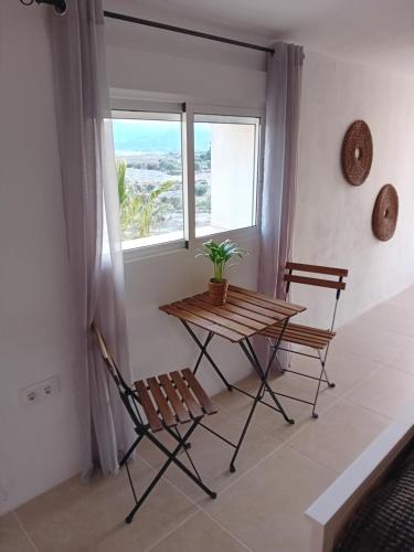 a table and two chairs in a room with a window at Casa nuestro sueño in Partaloa