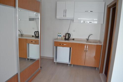a kitchen with wooden cabinets and stainless steel appliances at KUYAŞ OTEL in Golbası