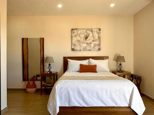 um quarto com uma cama com uma pintura de flores na parede em Casa Berty 2 em Ensenada