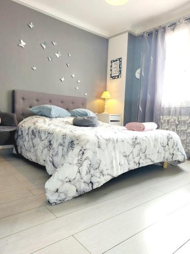 - une chambre avec un lit avec des oiseaux sur le mur dans l'établissement Le Nid, à Villecroze