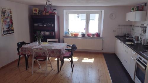kuchnia ze stołem i krzesłami oraz kuchnia z oknem w obiekcie Nice + sunny room, balkony, all facilities... w Trewirze