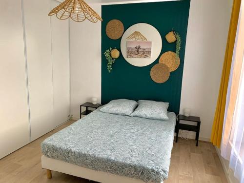 ein Schlafzimmer mit einem Bett und einer grünen Wand in der Unterkunft T2 Cosy near to Disney - Paris - Airport in Meaux
