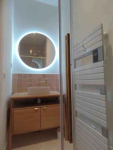 une salle de bain avec un lavabo et un miroir dans l'établissement La Glycine, Appartement d'architecte avec vue sur jardin, à La Courneuve