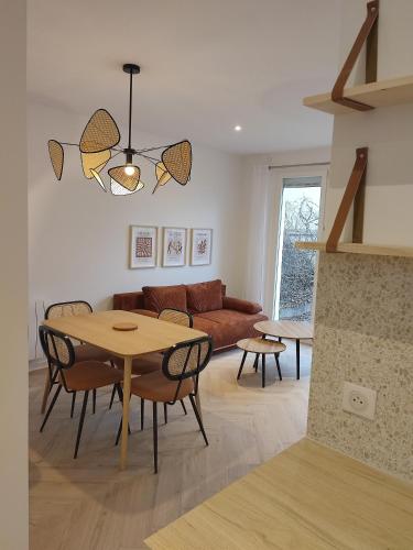 un salon avec une table et un canapé dans l'établissement La Glycine, Appartement d'architecte avec vue sur jardin, à La Courneuve