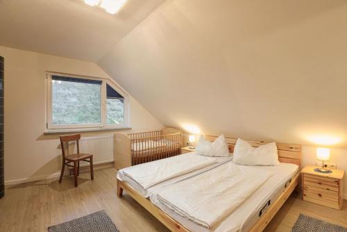 - une chambre avec un lit, une chaise et une fenêtre dans l'établissement Ferienhaus Reinerzau "Kleine Kinzig", 