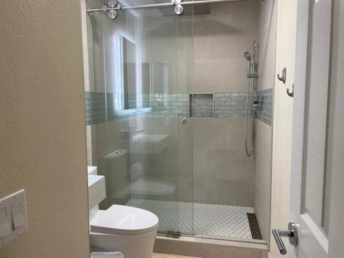 a bathroom with a toilet and a glass shower at Newly Remodeled Family Friendly 3B/2B House in Henderson