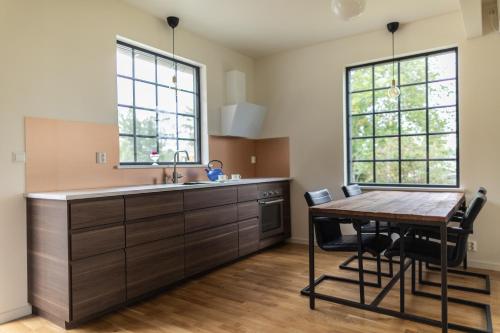 eine Küche mit einem Tisch, einem Waschbecken und 2 Fenstern in der Unterkunft A Place to Call Home in Skellefteå
