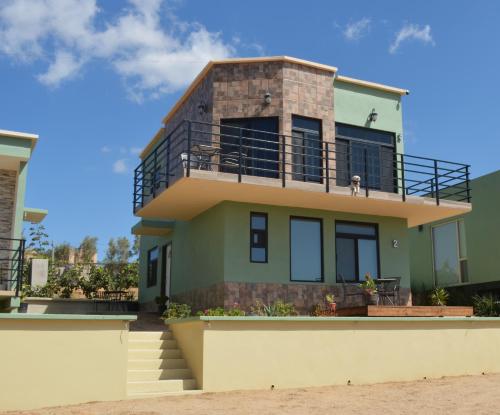 ein Haus am Strand mit einem Hund auf dem Balkon in der Unterkunft Casa Berty 4 in Ensenada