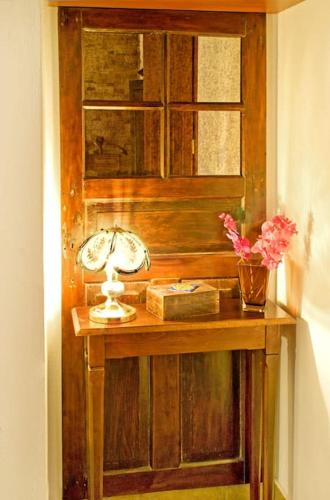 a table with a lamp and a vase of flowers at Αρχοντικό Ειρήνη - 6 Metsovo in Metsovo