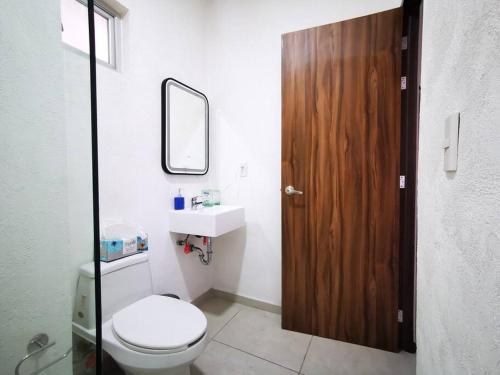 uma casa de banho com um WC e uma porta de madeira em Escenia Loft Deluxe em Guadalajara