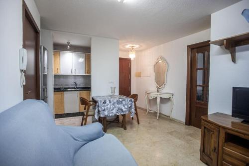 uma sala de estar com uma mesa e uma cozinha em Elvira 81 em Granada