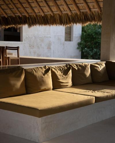 a couch sitting under a thatched roof at Mazul Puerto Escondido in Tlachicón