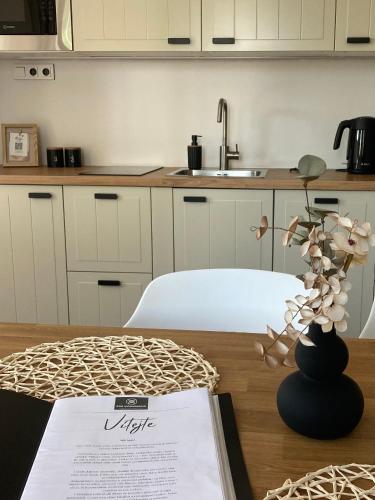 a kitchen with a table with a vase with flowers at Pod vinohradem - apartmány & vinné sklepy in Mutěnice
