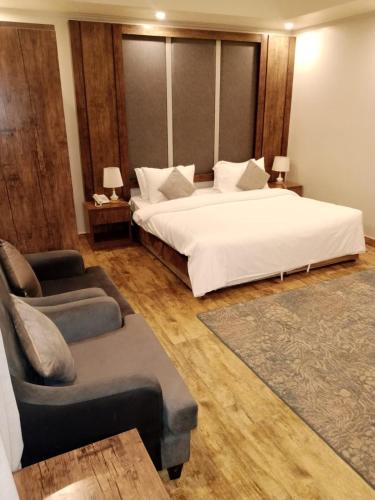 吉達的住宿－فندق العنقود - قريش，一间卧室配有一张床、一把椅子和一张沙发