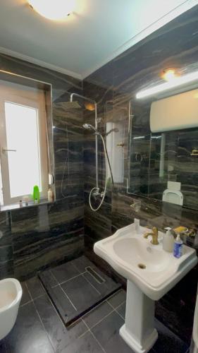 ein Bad mit einem Waschbecken und einer Dusche in der Unterkunft Franci's Apartment no.3 in Tirana