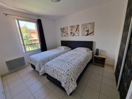 une chambre avec deux lits et une fenêtre dans l'établissement Côte d’Azur, South of France, 6 persons, full airco, pool, close to beach, à Roquebrune-sur Argens