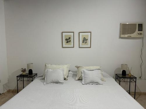 a bedroom with a white bed with two tables at Departamento Paso in Federación