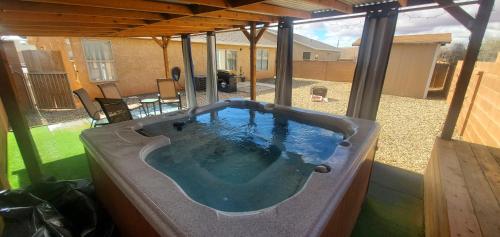 a hot tub in the middle of a patio at I Deal Lake Powell Home 3BR, Jacuzzi, BBQ, Firepit in Page