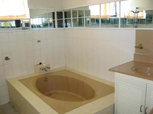 a large tub in a bathroom with a sink at Villa Nickerie/ Suriname in Nieuw Nickerie