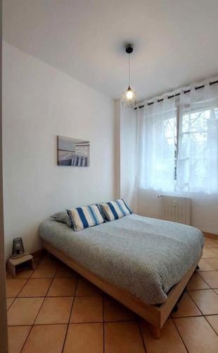 une chambre avec un lit dans une pièce avec une fenêtre dans l'établissement Le calme au centre-ville dans une cour intérieure, avec place de parking privée, à Dieppe