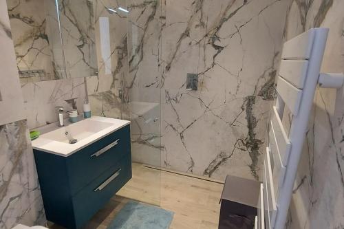 ein Badezimmer mit einem Waschbecken und einer Marmorwand in der Unterkunft Villa avec piscine proche mer et saint tropez in Grimaud