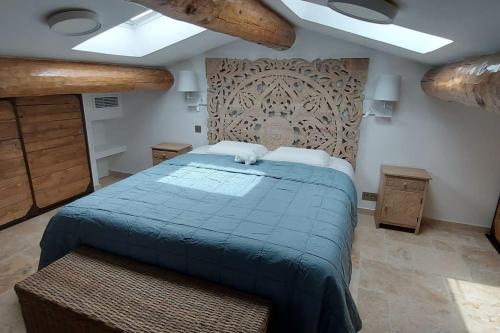 ein Schlafzimmer mit einem Bett mit einer blauen Bettdecke in der Unterkunft Villa avec piscine proche mer et saint tropez in Grimaud