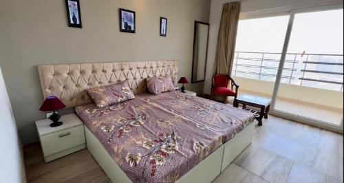 ein Schlafzimmer mit einem großen Bett und einem großen Fenster in der Unterkunft Paramount Golfforeste in Greater Noida