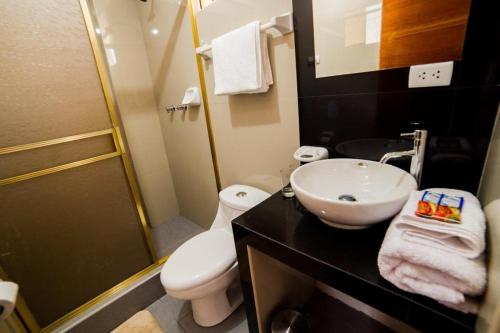ein Badezimmer mit einem weißen Waschbecken und einem WC in der Unterkunft The White house in Ollantaytambo