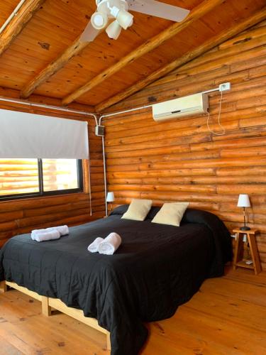 ein Schlafzimmer mit einem Bett in einem Holzzimmer in der Unterkunft Cabañas Punta Arena in San Pedro
