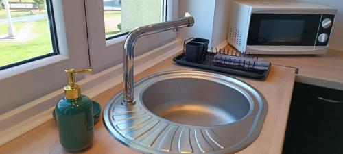 a sink with a faucet next to a computer monitor at Apartament na Poli in Wałbrzych