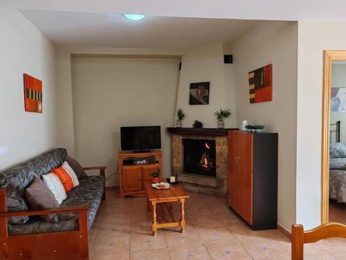 sala de estar con sofá y chimenea en Ruralguejar, en Güéjar-Sierra