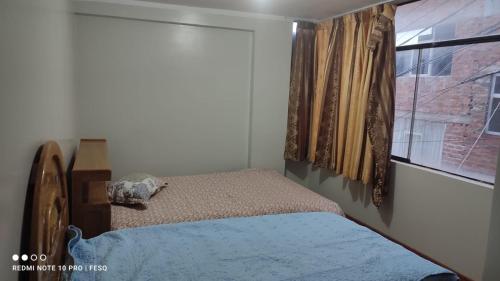 ein kleines Schlafzimmer mit einem Bett und einem Fenster in der Unterkunft Antawara in Puno