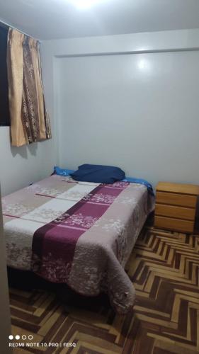 ein Schlafzimmer mit einem Bett mit einer Decke darauf in der Unterkunft Antawara in Puno