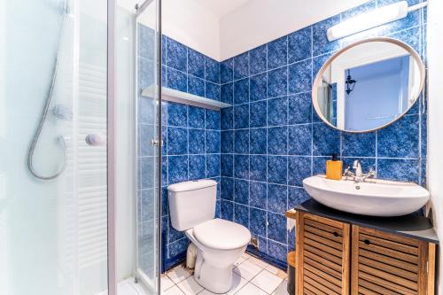 ein blau gefliestes Bad mit WC und Waschbecken in der Unterkunft T2 Jardin Privé - Lille Europe in Lille