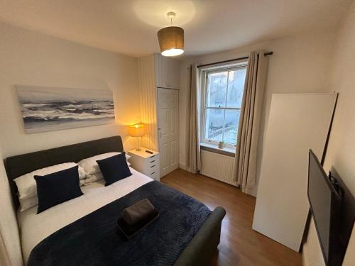 sypialnia z łóżkiem i dużym oknem w obiekcie Spacious Central Brighton Apartment w Brighton and Hove
