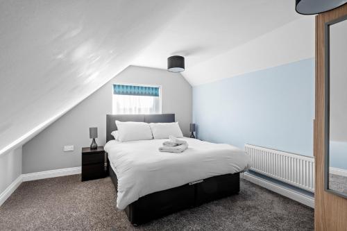 a bedroom with a bed with white sheets and a window at Cosy 2 Bedroom Flat in East Ham, Close to Excel in London