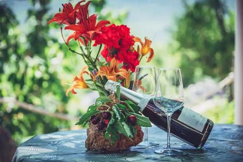 une table avec un vase de fleurs et un verre de vin dans l'établissement Robinson Haus Ivan, à Makarska
