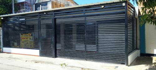 a black garage door on the side of a building at Habitaciones Cataleya Valledupar in Valledupar